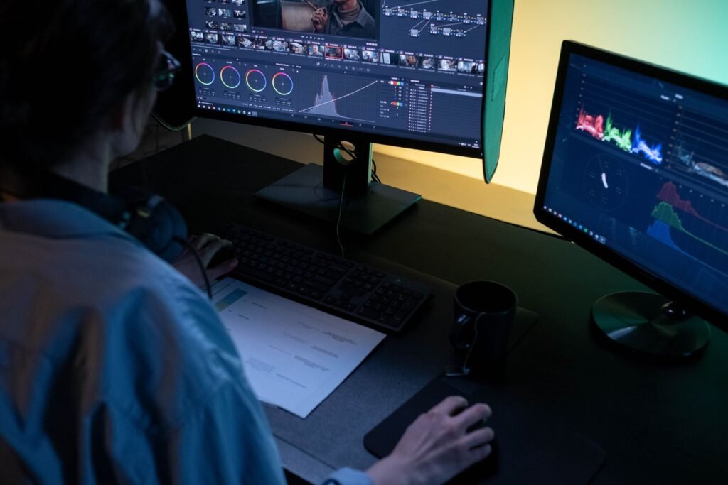 Professional reviewing video footage on dual monitors